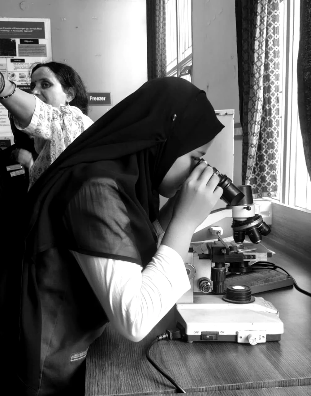 A student works with a microscope during a science activity.